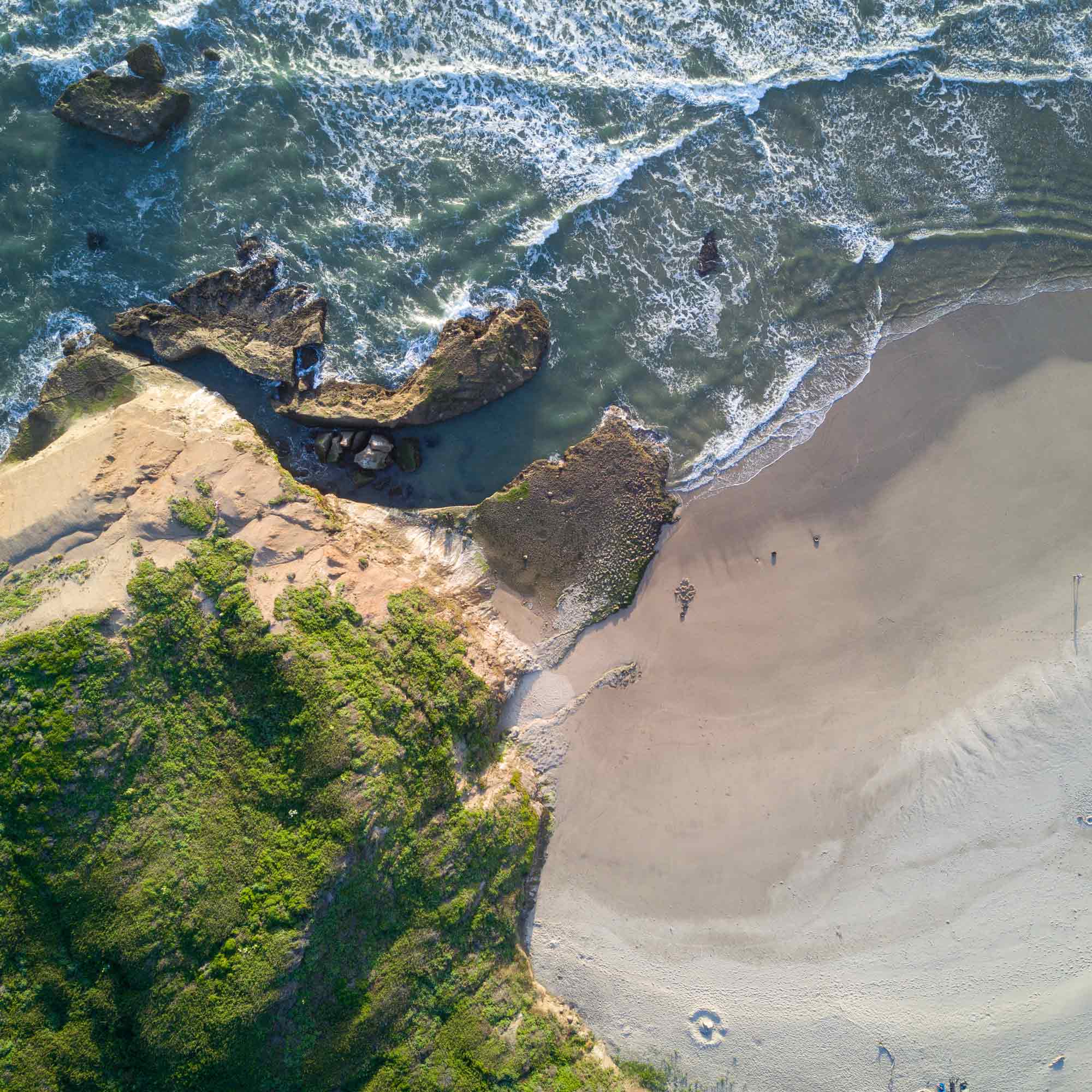 ' . __( 'An aerial view of waves crashing against a shore.' ) . '